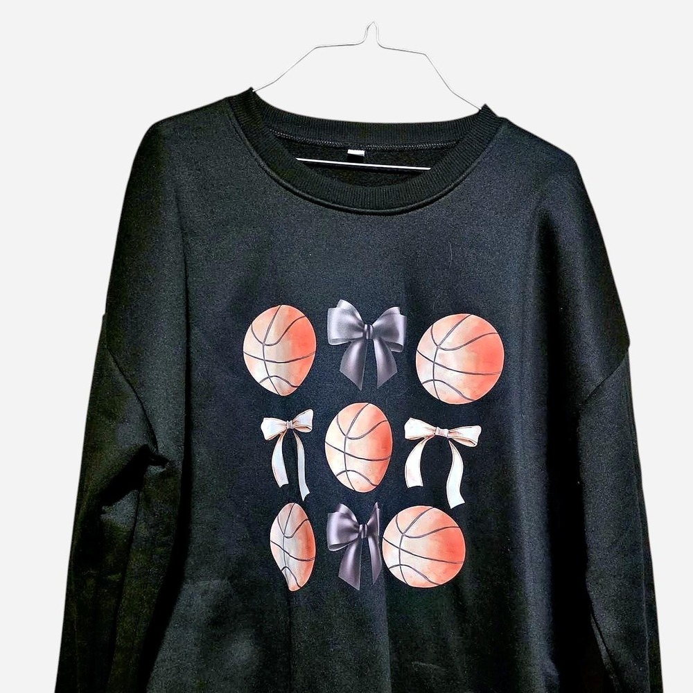 Black crewneck sweatshirt with graphic of basketballs and bows